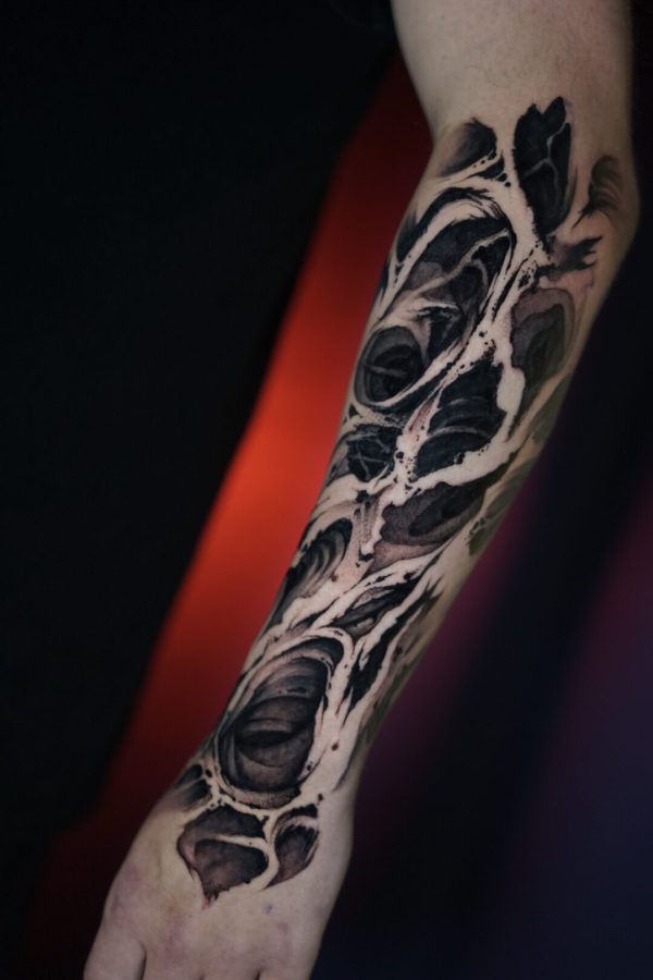 abstract freehand blackwork tattoo with organic flowing shapes on forearm By Mihaly Forgony