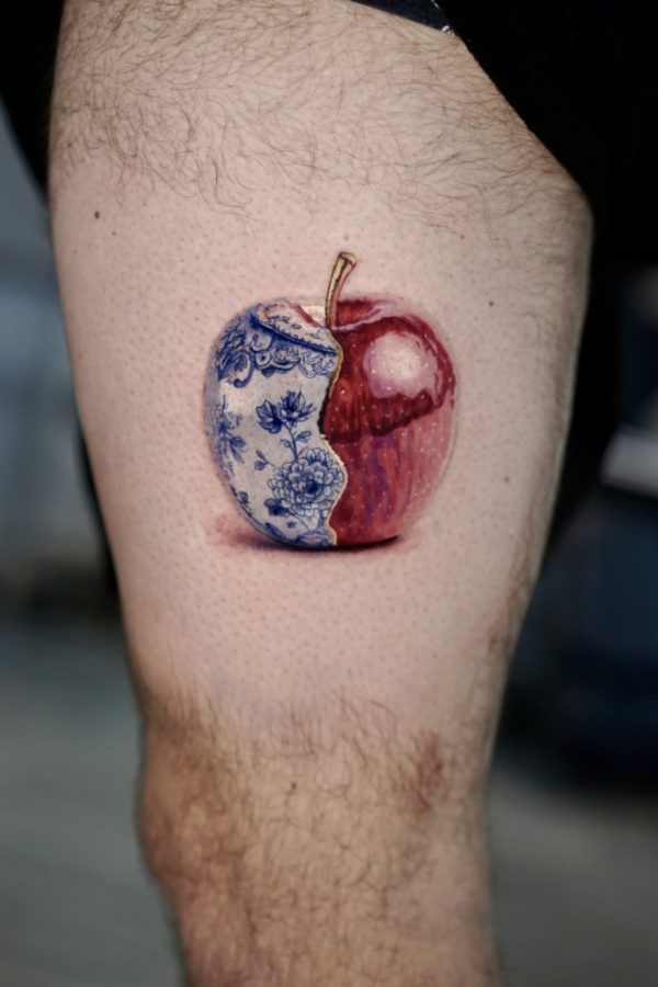 realistic apple color tattoo with porcelain pattern and red interior by Mihaly Forgony