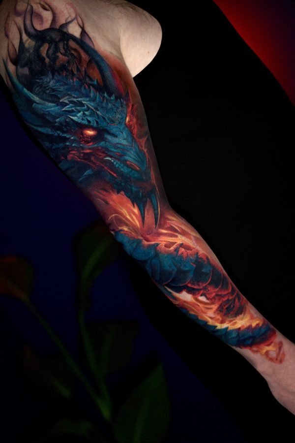 colorful realistic dragon tattoo full sleeve with blue and red lighting effects by Mihaly Forgony